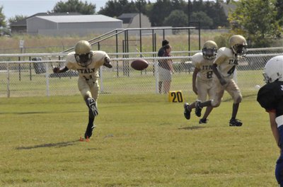 Image: Brooks kicks off — Jasean Brooks(11) kicks off for the IYAA B-Team Gladiators against the Rice Bulldogs while teammates Jacob Wiser(8) and Jaylon Davis(4) rush upfield.