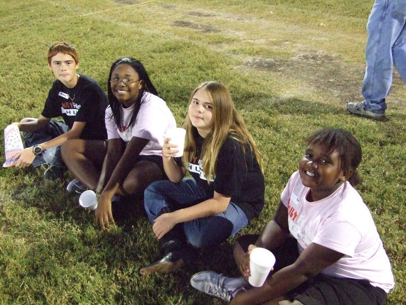 Image: Ready to worship — (L-R) Jeremy, Kierra, Jade and Alexis wait on the grass at Willis Field and listen to the Christian band and the testimonies from other kids on Wednesday night.