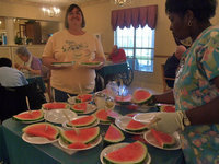 Image: Watermelon Anyone? — Carolyn Powell (activities director) is ready to serve up the watermelon.
