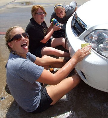 Image: Fun in the suds — Madison Washington, Emily Stiles and Drenda Burk sit in the suds while soaping another car.