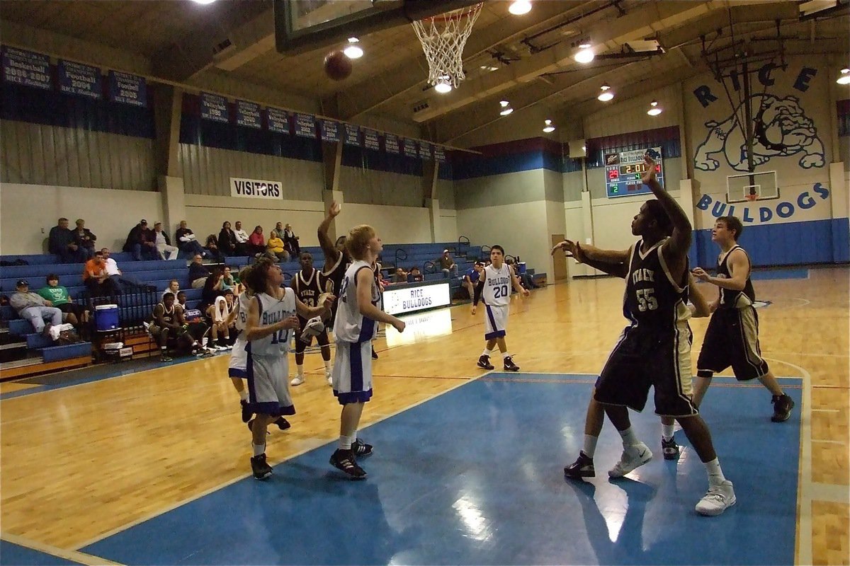 Image: Slick shot — Jalarnce Jamal Lewis(30) hits a fade-away as Paul Harris(55) and Haden Woods(1) move in for the board.