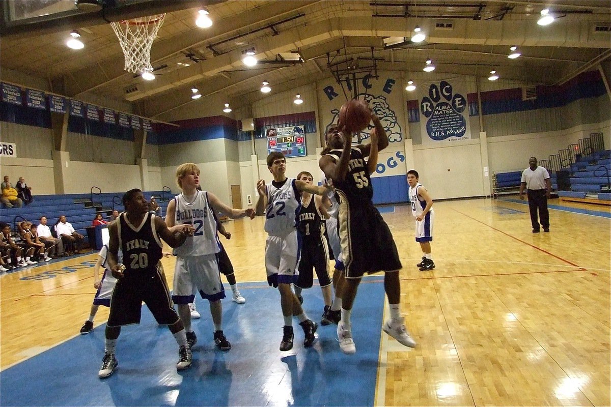 Image: Strength in the post — Paul Harris(55) grabs a rebound for the J.V. Gladiators.