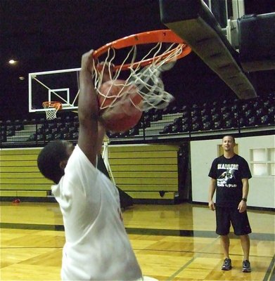 Image: Norwood slams — Kenneth Norwood executes a two-handed jam during the slam dunk competition as Coach Cal looks on.
