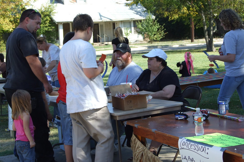 Image: Carnival for the kids — Rev. Beverly Hamilton and Randy Rudd exchange money for coupons.