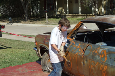 Image: James whacks a car — James Youngblood smashes a car five times for $1.