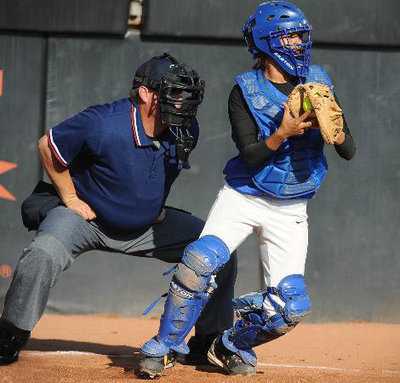 Image: Behind the masks — UIL umpire Joe Windham scans the action behind the Waco Robinson Rockettes’ senior catcher, Crystal Alonzo, at McCombs Field on the University of Texas campus during the 3A semifinal game between Robinson and Paris North Lamar.
