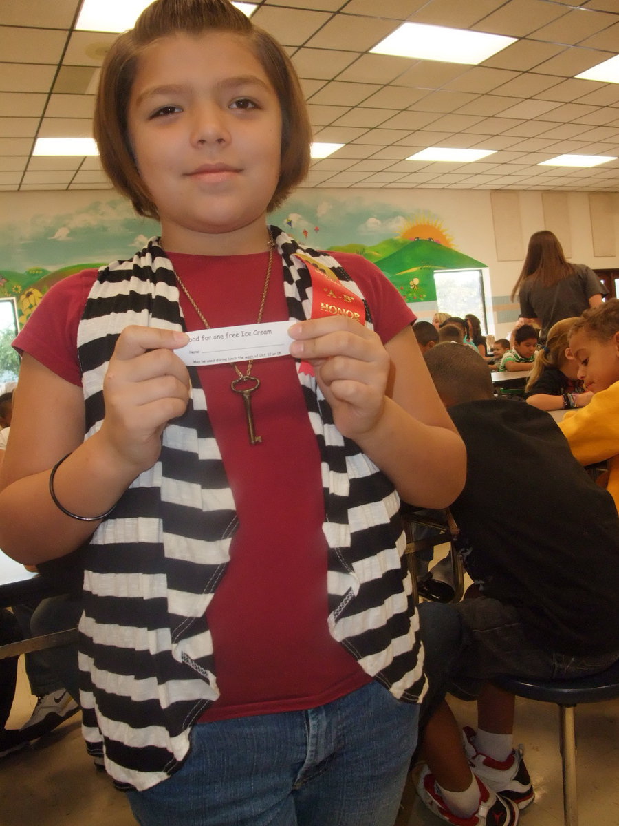 Image: Lexie Delarosa — She is holding an ice cream coupon she received for perfect attendance.