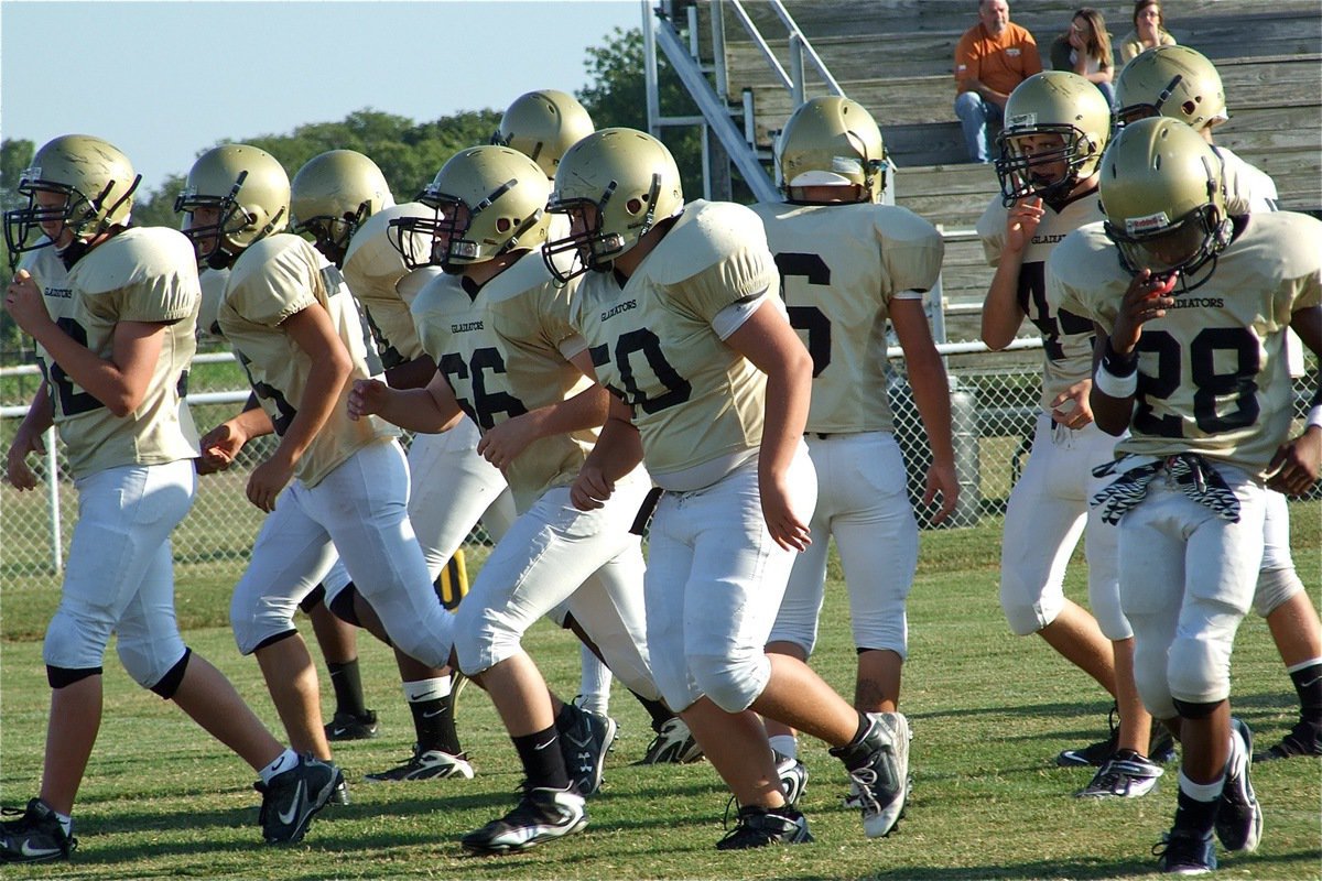 Image: Huddle scatters — The JV Gladiators break the huddle to take on the Palmer Bulldogs.