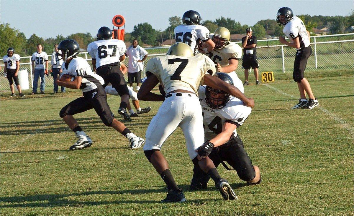 Image: Dog gets loose! — Hank Seabolt(76) and Paul Harris(7) try to contain a Bulldog on the loose.