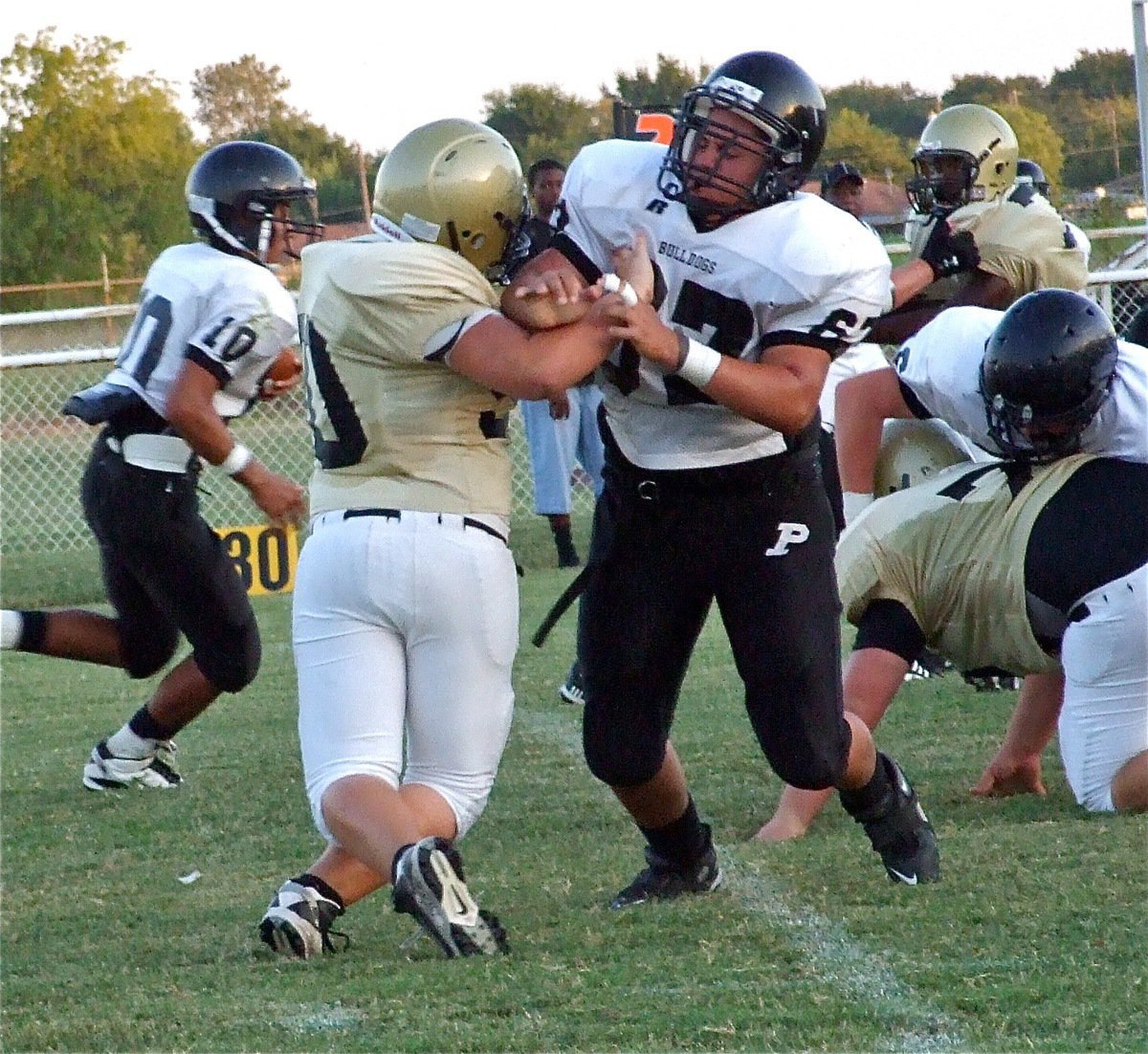 Image: Close contact — Italy’s Zain Byers(50), Hank Seabolt(76) and Paul Harris(7) close in on the Palmer runner.