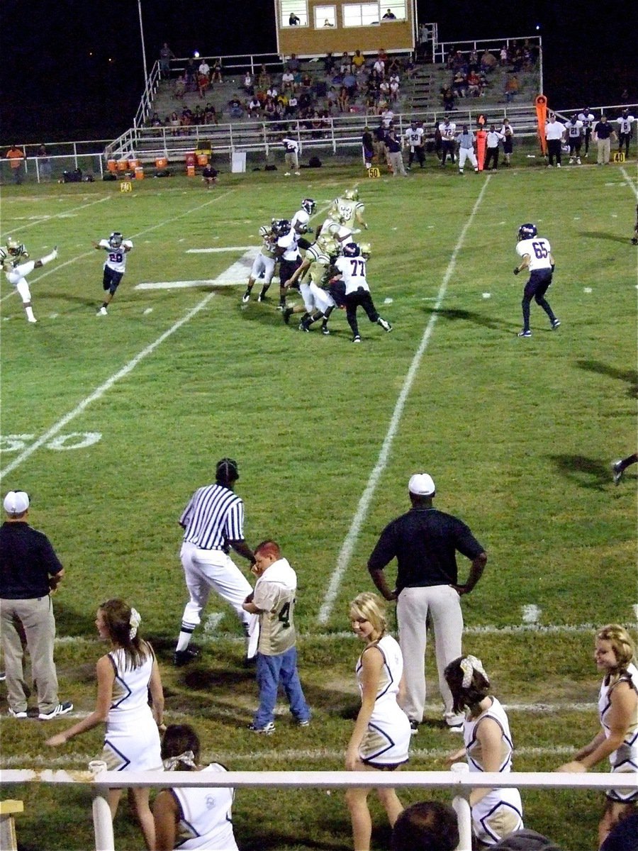 Image: Booth “I” view — The cheerleaders cheer, the coaches coach, the referees officiate, Jasenio Anderson punts and the Gladiators play on…