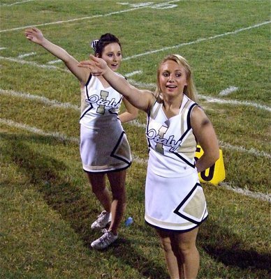 Image: Kick that ball! — Haylee Love and Mary Tate cheer before a kickoff by the Gladiators.