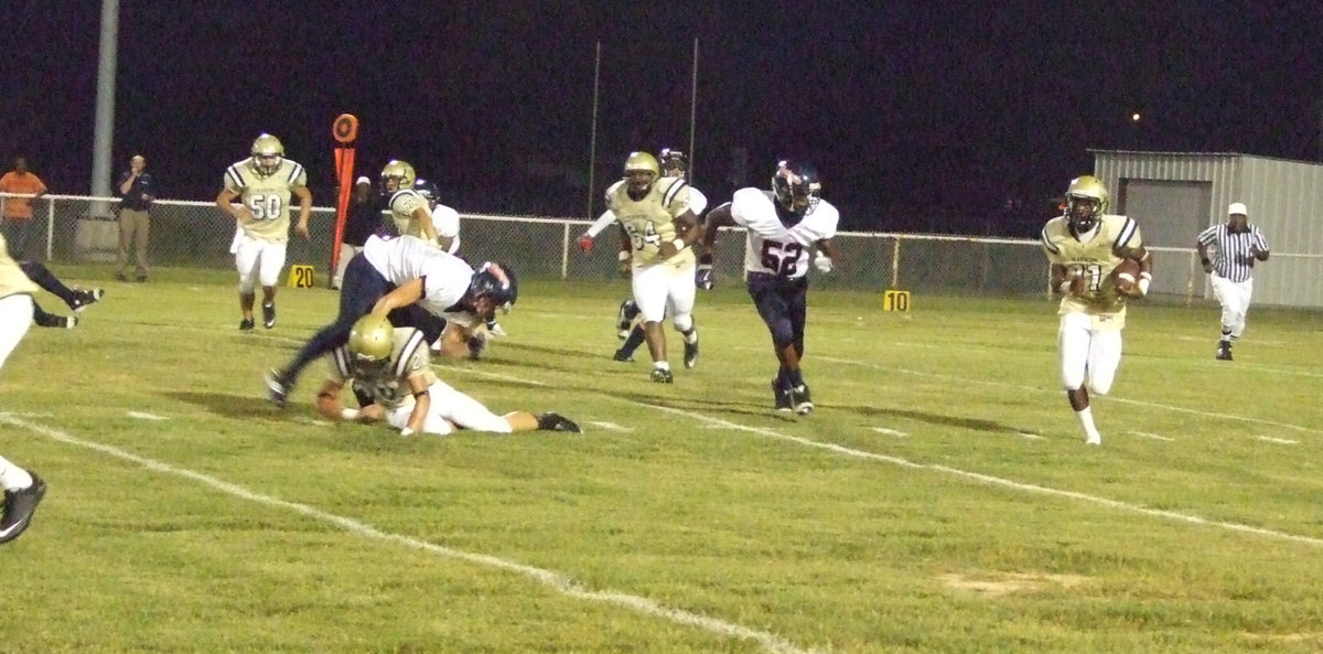 Image: Kyle clears the way — Jasenio Anderson (11) attacks the left side of the Mustangs defense, following the lead block Kyle Jackson (28).