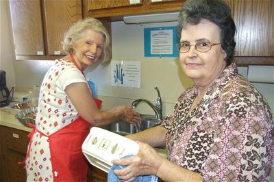 Image: Behind the scenes — Barbara Little and Nelda Commons clean up after serving lunch to the community.