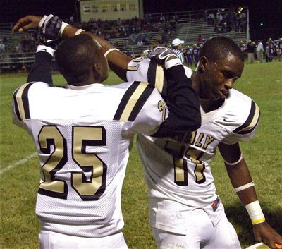 Image: Helping a teammate — Corrin Frazier(25) helps stretch the throwing arm of Gladiator quarterback Jasenio Anderson(11) who injured his shoulder early in the contest.