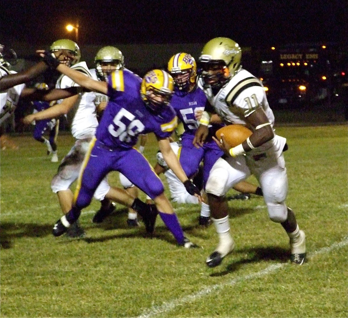 Image: Looking for space — Jasenio Anderson(11) runs left around the Bison defense thanks to a block from Larry Mayberry(77).