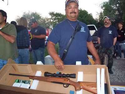 Image: Assistant Chief Carlos Garza — The Milford Volunteer Fire department were there selling sausage on a stick, chips and drinks and raffle tickets. Assistant Chief Garza (Milford Volunteer fireman) said, “We are are having a raffle for a 270 rifle and the winner will be selected October 30th. The money we raise will be for needed equipment for the department.”