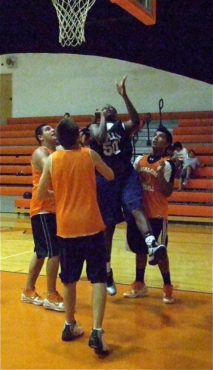 Image: Can’t stop him — Gladiator big man Larry Mayberry scores inside despite being surrounded by three Eagles.