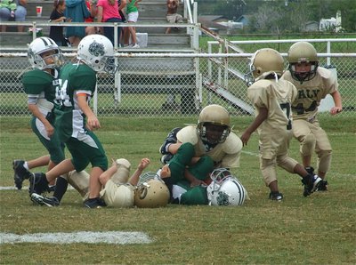 Image: Teaming up — Jaiden Barr and Ty Cash bring down the Wildcat quarterback as Damorion Sargent(7) and Bryce DeBorde(44) moved in to help.