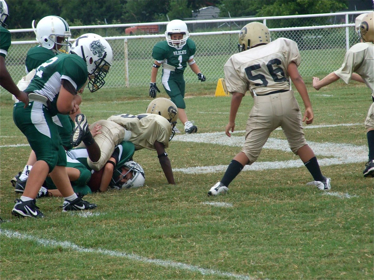 Image: Crunch! — Taron Smith(10) tackles a Wildcat runner.