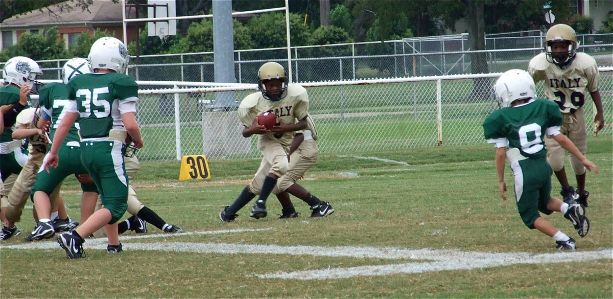 Image: Minors on the move — IYAA Minors running back Ricky Pendleton(3) takes the handoff and heads for open field.