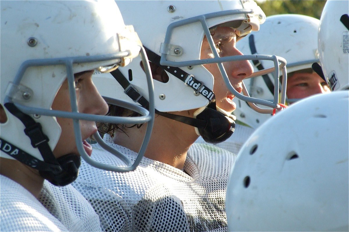 Image: In the huddle — Ryan Connor and Chace McGinnis listen to every word spoken by Coach Josh Ward.