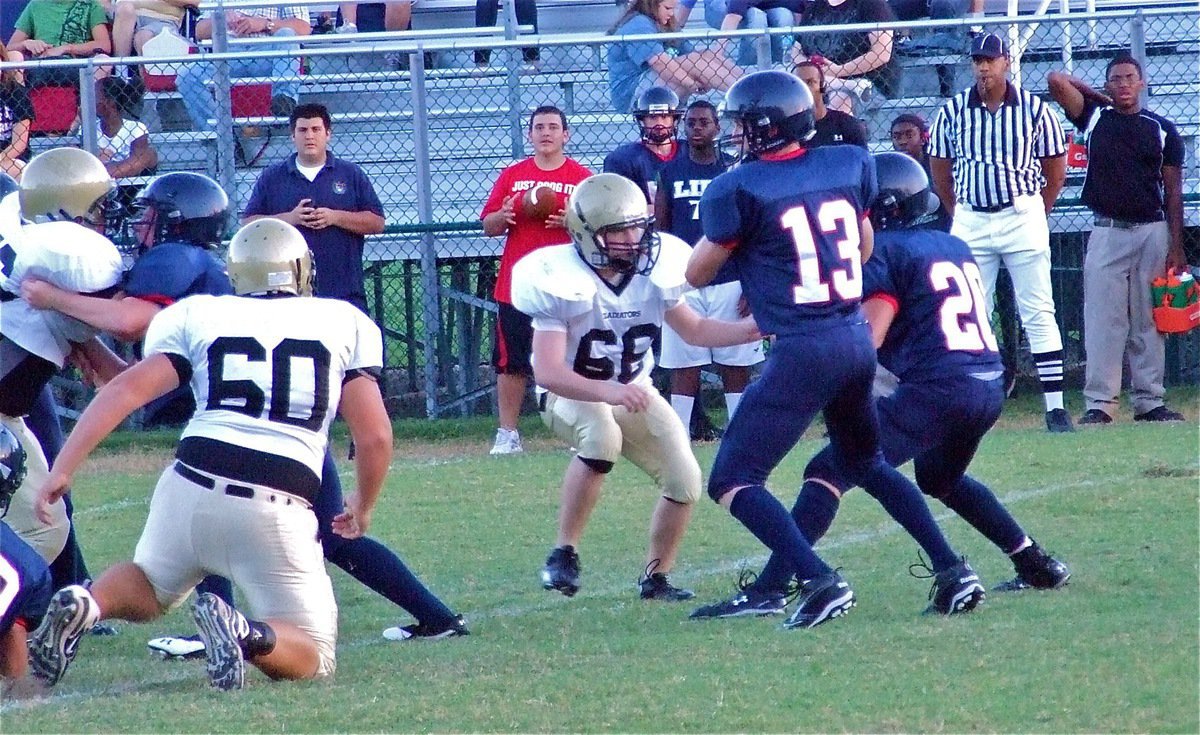 Image: Attack mode — Italy’s Hank Seabolt(76), Kevin Roldan(60) and Jake Escamilla(66) put pressure on the Mustang quarterback during the JV game.