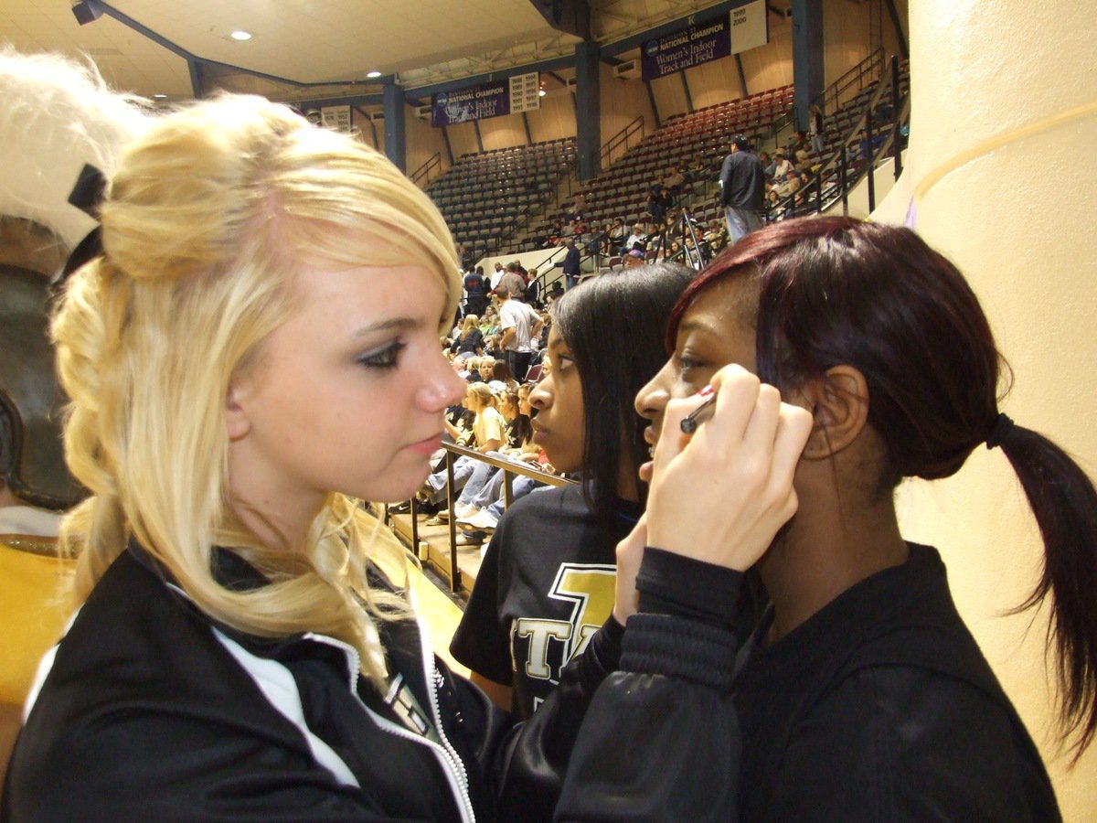 Image: Getting ready — Sierra Harris paints an Italy player’s number on Jameka Copeland’s face as our fans get decorated before the game.