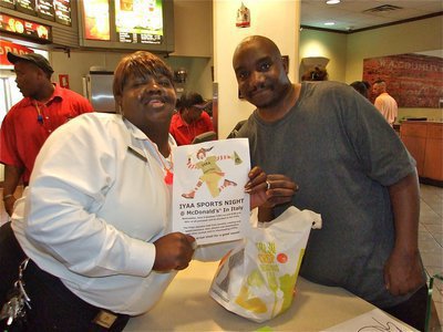 Image: Glad to help — Jason D. from Mississippi purchases a full bag of apple pies and chocolate chip cookies from McDonald’s employee Brenda Smith in an effort to support the IYAA of Italy.