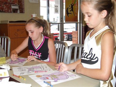 Image: Purple crayons — Kirby Nelson and Karley Nelson work intensely on the Grimace coloring contest during IYAA Sports Night hosted by McDonald’s in Italy.