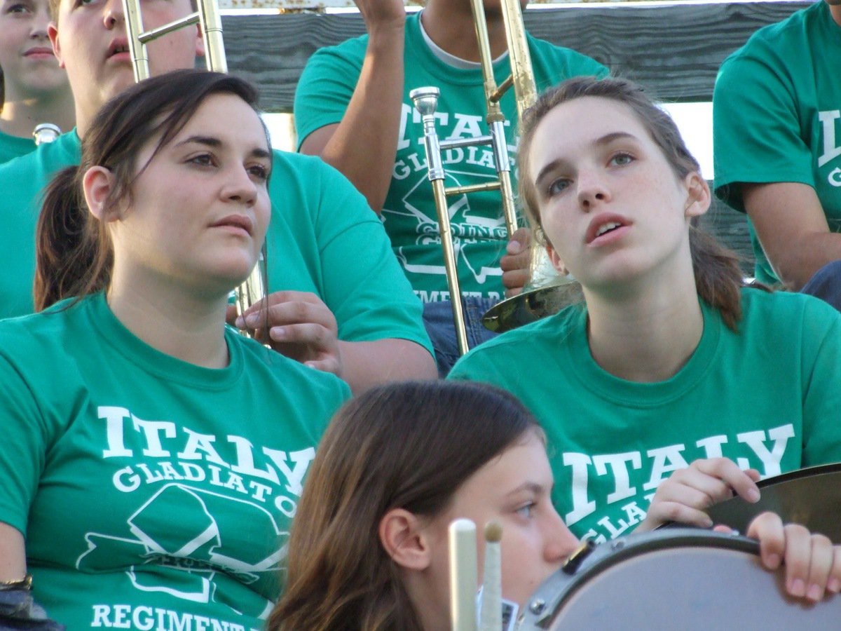 Image: View from the band’s stand — Members of the Gladiator Regiment Band, Kaytlyn Bales and Melissa Smithey, check out the Panthers band and cheerleaders.