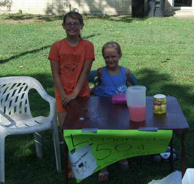 Image: The Gage Corporation — Cassidy and Brooke took a day out of their busy summer schedules to offer refreshment to very thirsty passersby for a small fee.  Their ultimate goal for this sale was to buy a new trampoline for the family.