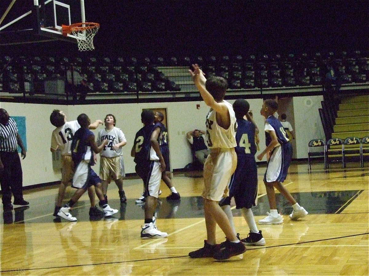 Image: Colton shoots a jumper — Colton Petrey(23) shoots a jumper as Chace McGinnis(13) and John Byers(44) await the results.