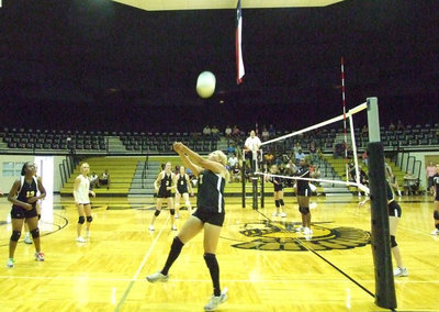 Image: Over the head — Megan Richards helps the Lady Gladiators and keeps the ball in action.