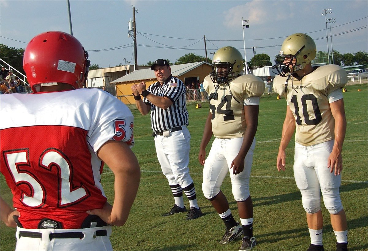 Image: Captains at midfield — Italy’s designated captains for the JV’s season opener were Adrian Reed(64) and Chase Hamilton(10).