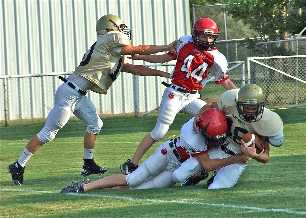 Image: Italy’s on the move — Chase Hamilton(10) gets in one last block before Justin Wood(48) gets taken down after a nice gain.