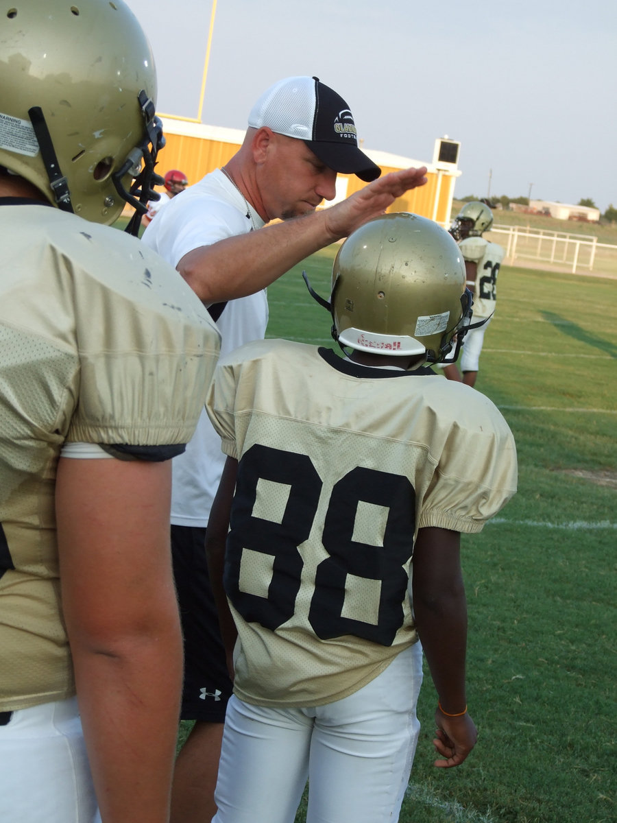 Image: Good job — New Defensive Coordinator Coach Jeff Richters, gives Dominic Wilson(88) a tap on the helmet for working hard.