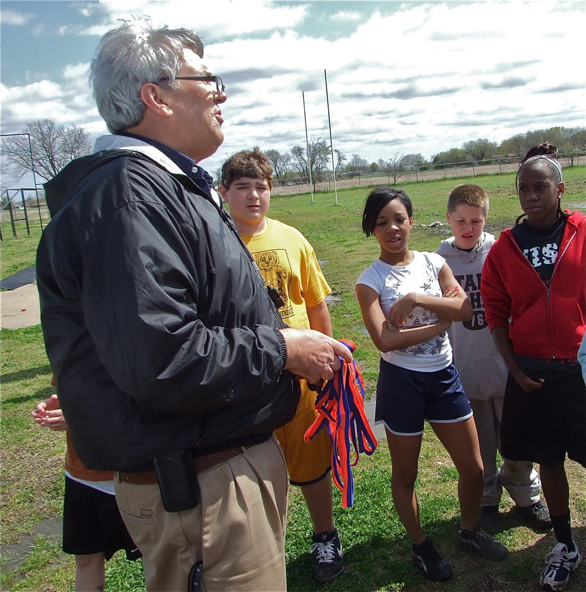 Image: Coach Coleman — Italy Junior High Track coach Stephen Coleman proudly passes out the medals to team members previously earned at the Dallas Gateway track meet.