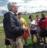 Image: Coach Coleman — Italy Junior High Track coach Stephen Coleman proudly passes out the medals to team members previously earned at the Dallas Gateway track meet.
