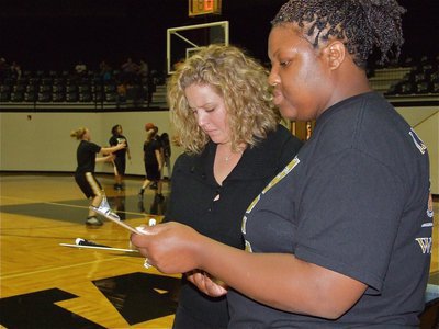 Image: Stacy and Brendetta — Coach Stacy McDonald hands pre-game announcer, Brendetta Reed, the lineups.