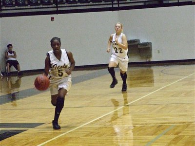 Image: Jameka pushes the ball — Freshman Jameka Copeland(5) pushes the ball up court as sophomore Megan Richards(22) heads out to the wing.