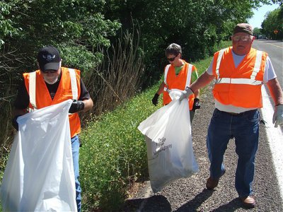 Image: Fun in the sun — Gary McNeely, along with Donna and Earl Goodwin, walk Hwy 77 during the Southern Cruisers Ellis County 326 Adopt-a-Highway cleanup effort.