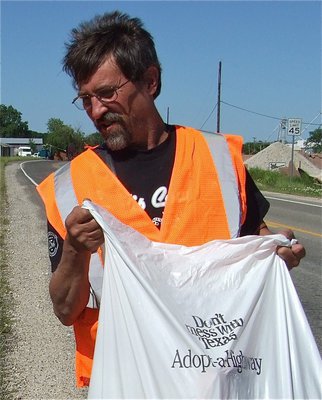 Image: No messing with Mark — Mark Jones displays the “Adopt-a-Highway” trash bag that he’s using to haul debris collected from alongside Hwy 77 in Italy.