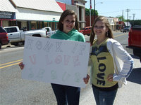 Image: Honk if you love Jesus! — Ella Presley and Kaitlyn Harrison hold their sign high to help draw potential customers to Avalon Baptist Church’s Bake Sale on Main Street in downtown Italy.