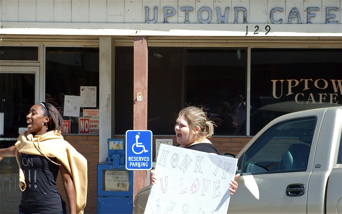 Image: Working hard — Ra’Gene Miles and Mallory Valdez try to attract potential customers for the Avalon Baptist Church’s Bake Sale in front of Doris Mitchell’s Uptown Cafe in downtown Italy.