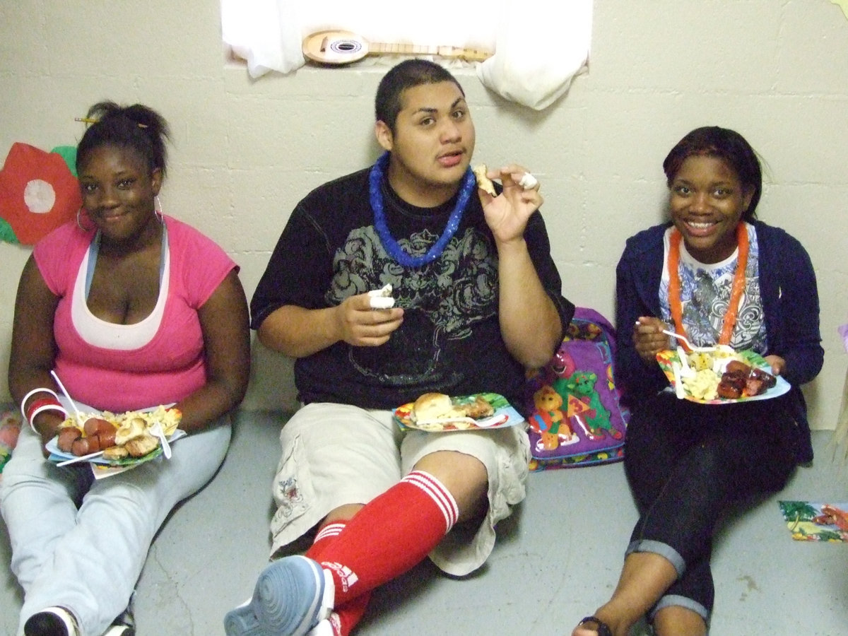 Image: This food is awesome — Sha’Darion Jones, Alonso Ayala and Shativia Cockran enjoy the luau.