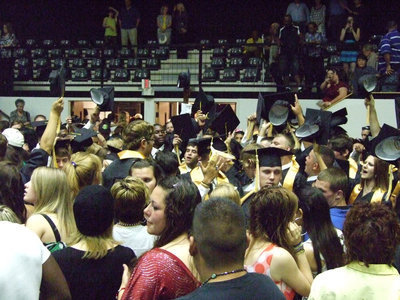 Image: Hats off — The graduates gather together and send their cares up in the sky.
