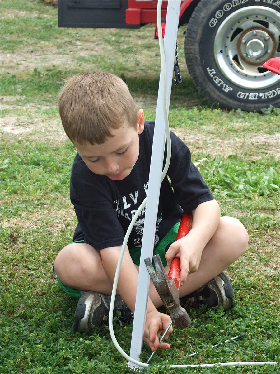 Image: Bryce helps out — Bryce DeBorde helps the IYAA team set up their tent during the cook-off.