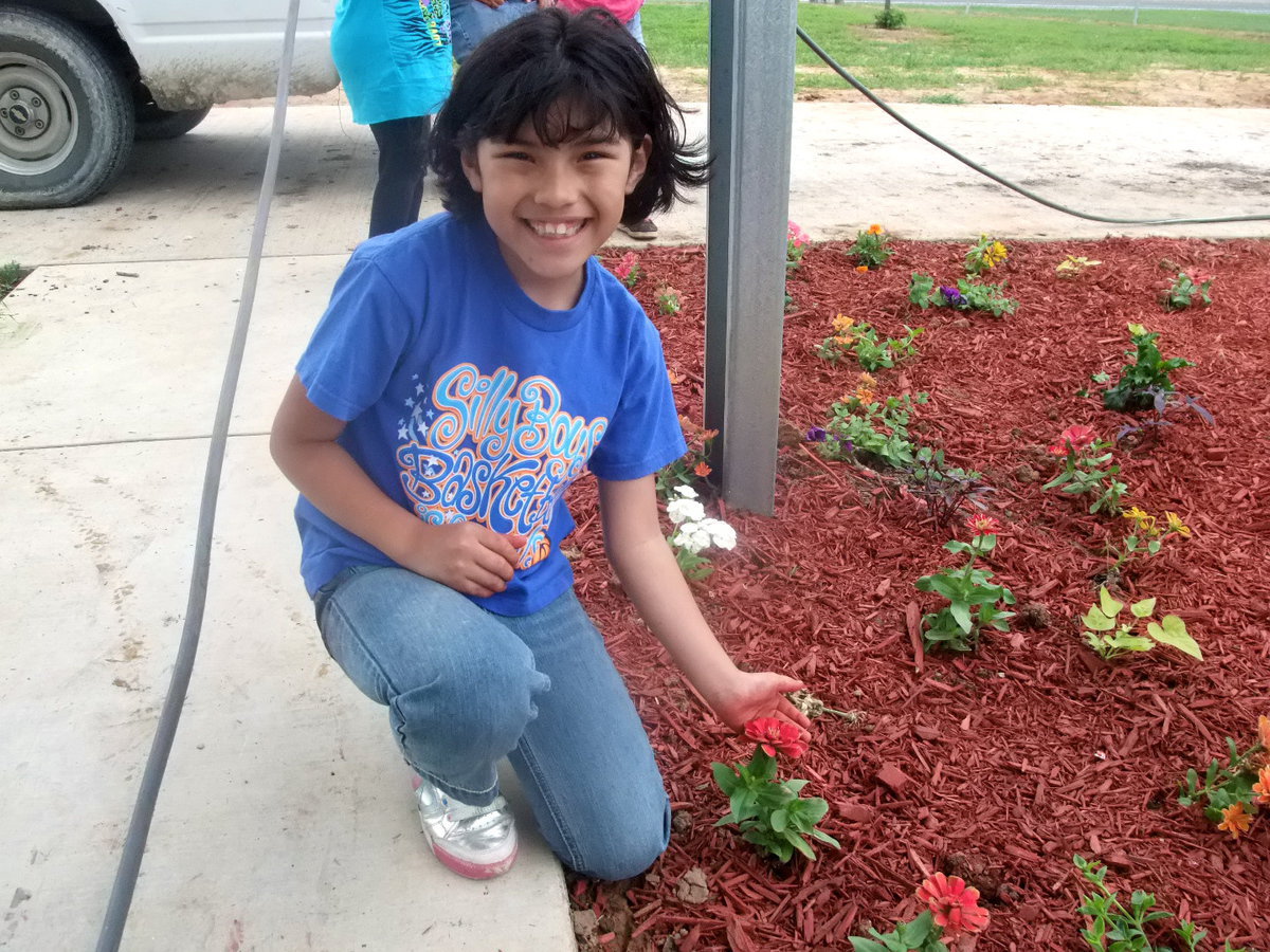 Image: Leslie Gallardo — Leslie is showing us her flower.