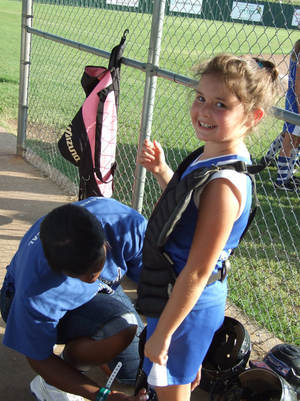 Image: A smile and some help — Milford’s catcher #6 Bree Brown gets a little help from Assistant Coach Veronica Rankin as she suits up for the State Tournament held in Clifton this week.
